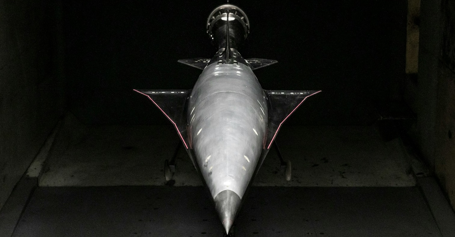 A slender high-speed vehicle model mounted on a sting in a wind-tunnel test section
